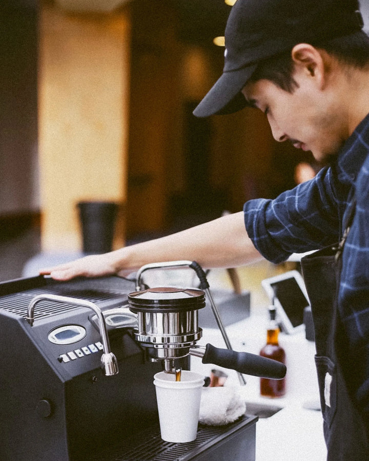 Barista making coffee with an espresso machine